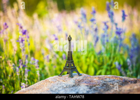 Miniatur Eiffelturm in Lavendelfeld. Denkmal Figur Stockfoto