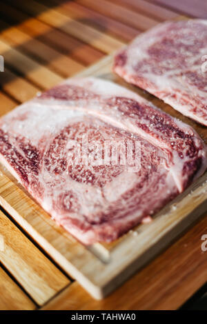 Zwei Rohmaterial wagyu Kobe Steaks auf einem Schneidebrett Stockfoto