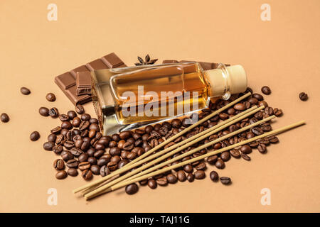 Reed Diffuser, Kaffeebohnen und Schokolade auf farbigen Hintergrund Stockfoto