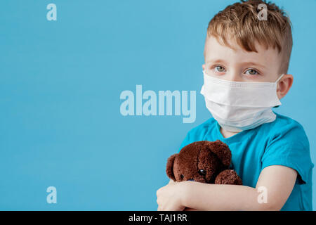 Cute little boy mit Zerstäuber auf blauem Hintergrund. Allergie-Konzept. Stockfoto