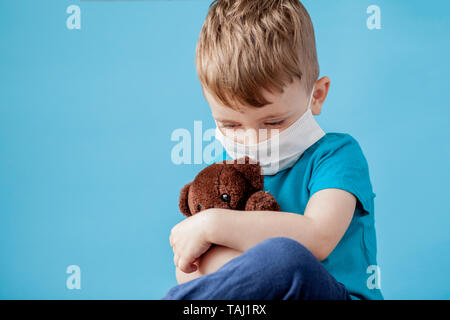 Cute little boy mit Zerstäuber auf blauem Hintergrund. Allergie-Konzept. Stockfoto