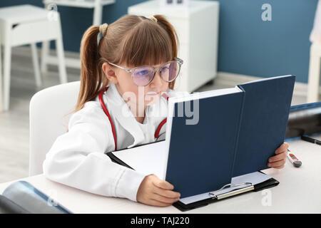 Süße kleine Mädchen gekleidet als Arzt spielen zu Hause Stockfoto