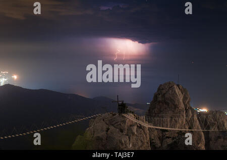 Nacht Gewitter über dem Meer. Lightning auf das Wasser des Schwarzen Meeres. Rocky Mountain Klippen. Hängende Pfad zu den Ai-Petri top. Kreuz peak Dark Light Stockfoto