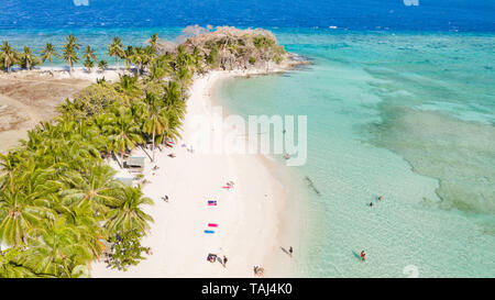 Antenne seascape Touristen genießen den tropischen Strand. tropische Insel mit Sandstrand, Palmen. Malcapuya, Philippinen, Palawan. Tropische Landschaft mit blauen Lagune, Coral Reef Stockfoto