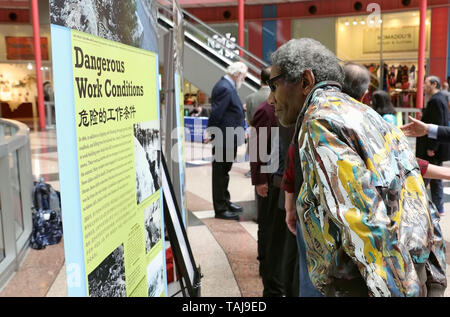 Chicago, USA. 24. Mai, 2019. Ein Besucher schaut sich ein Bild von der Foto-ausstellung "Die chinesische und die Eisen Straße - Bau der Transkontinentalen" in Chicago, USA, am 24. Mai 2019. Eine Fotoausstellung in Erinnerung an den Beitrag der chinesischen Wanderarbeitnehmer zu US-amerikanischen transkontinentalen Eisenbahn vor 150 Jahren weg von Freitag an Thompson Center in Chicago. Die Ausstellung "Die chinesische und die Eisen Straße - Bau der Transkontinentalen', wird für die letzten sieben Tage im Staatseigenen Gebäude. Credit: Wang Ping/Xinhua/Alamy leben Nachrichten Stockfoto