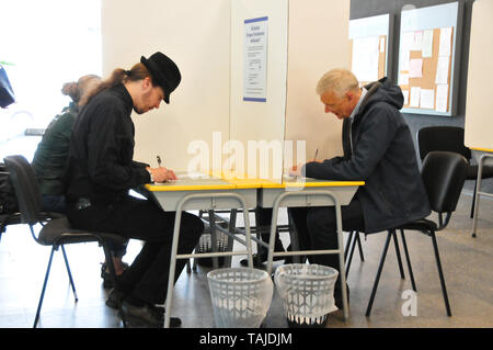 Lettland, Lettland. 25 Mai, 2019. Lettische Premierminister Krisjanis Karins (R) ist in einem Wahllokal während der Wahlen zum Europäischen Parlament in Riga, Lettland, 25. Mai 2019 gesehen. Die Wähler in Lettland ging zu den Abstimmungen am Samstag ihre acht Vertreter für das Europäische Parlament zu wählen, mit den Kandidaten der regierenden Mitte-Rechts-Parteien erwartet Die meisten zu gewinnen. Credit: Janis/Xinhua/Alamy leben Nachrichten Stockfoto