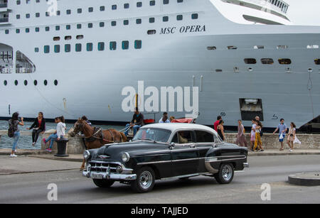 Havanna, Kuba - der 1950er Jahre amerikanische Vorbeifahren ein pferdefuhrwerk und eine Kreuzfahrt auf der Avenida del Puerto in der Nähe von Havanna Hafen. Klassische amerikanische Autos f Stockfoto