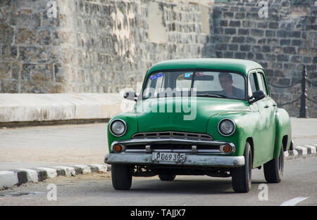 Havanna, Kuba - ein Taxi an der Vorderseite des Castillo de San Salvador de la Punta auf der Malecón Straße mit Blick auf Bucht von Havanna. Klassische amerikanische Autos aus dem 19. Stockfoto