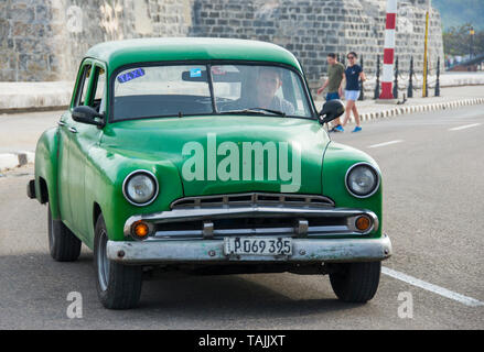 Havanna, Kuba - ein Taxi an der Vorderseite des Castillo de San Salvador de la Punta auf der Malecón Straße mit Blick auf Bucht von Havanna. Klassische amerikanische Autos aus dem 19. Stockfoto