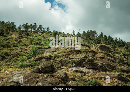 Rustikales Steinhaus auf einem hügeligen Landschaft mit Felsen und Büsche, in einem bewölkten Tag, in der Nähe von Villa Covelo. Wie die Portugiesische Schweiz für ihre Landschaft bekannt. Stockfoto