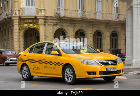 Havanna, Kuba - ein modernes Taxi passiert vor Hotel Plaza in der Nähe von Parque Central. Stockfoto