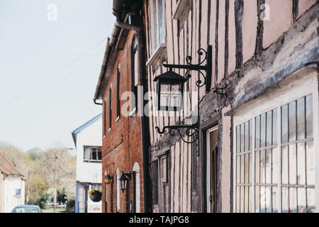 Alte Lampe an der Außenseite des Krummen Fachwerkhäusern Pastellrosa mittelalterliches Haus im Dorf von Lavenham, Suffolk, England, UK. Stockfoto