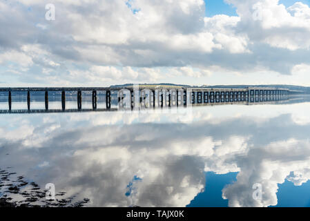 Blick auf eine leere Eisenbahnbrücke terminologiediensten ein Fluss auf einer leicht bewölkt Wintermorgen. Spiegelbild im Wasser. Stockfoto