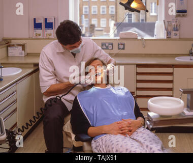 Zahnarzt arbeiten mit Patienten in der Chirurgie, Greater London, England, Vereinigtes Königreich Stockfoto