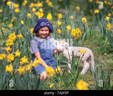 Junges Mädchen mit Lamm in Bereich der Narzissen, Hagley Park, Christchurch, Canterbury, South Island, Neuseeland Stockfoto
