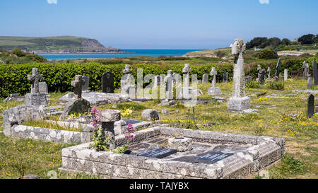 Auf dem Friedhof in St. Enodoc's Kirche mit dem Meer und Daymer Bay im Hintergrund. Stockfoto