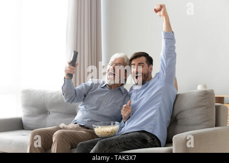 Ältere Menschen Vater und Sohn jubelnde Fernsehen Spiel zusammen Aufgeregt Stockfoto