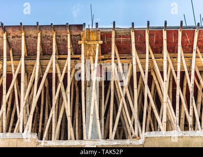 Ein Bambus Gerüst verwendet eine verstärkte Zement Beton Dach Tafel zu unterstützen. Die neu gegossen Dach ist nach links für ca. 7 Tage zu kurieren. Indien. Stockfoto