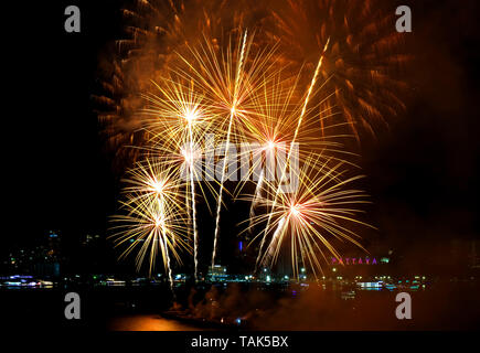 Atemberaubende Gold Farbe Feuerwerk in den Nachthimmel über Pattaya Bay explodiert, mit PATTATA Stadt schreiben öffentliche Sehenswürdigkeit auf dem Hügel, Thailand Stockfoto