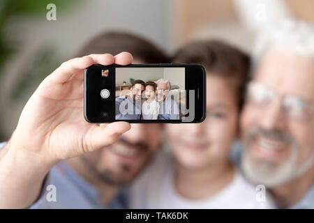 Lächelnd drei Generationen von Männern nehmen selfie auf dem Smartphone Stockfoto
