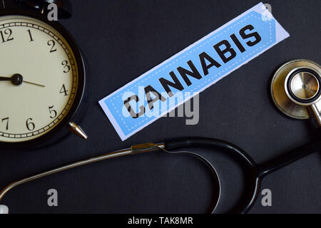 Cannabis auf dem Druckerpapier mit Healthcare Konzept Inspiration. Wecker, Schwarz Stethoskop. Stockfoto
