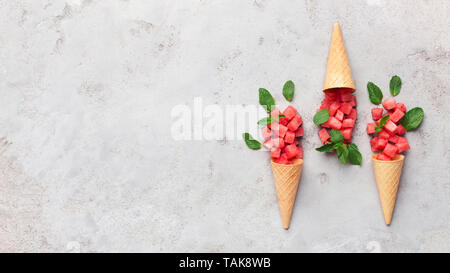 Stück Wassermelone im Waffle Kegel auf grauem Hintergrund Stockfoto