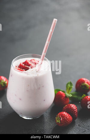 Strawberry smoothie Milchshake in Glas auf Schwarz konkreten Hintergrund. Vertikale Ausrichtung, getönten Bild Stockfoto