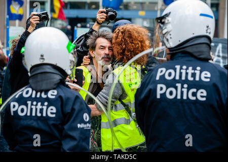 Eine gelbe Weste Paar gesehen umarmen vor der Bereitschaftspolizei während des Protestes. Hunderte von Gelb aus verschiedenen Teilen Europas protestierten gegen die EU-Parlament im EU-Wahlen, an der Brüsseler Nordbahnhof. Die Bereitschaftspolizei zeigte oben und stießen mit den Demonstranten. Stockfoto