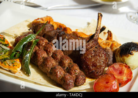 Ein Gericht von gegrilltem Mischung aus Fleisch (Lamm, Kebab, Lamb Ribs, Hühnchen Shish Tawook) und Gemüse (Tomaten, Zwiebel, Paprika). Stockfoto