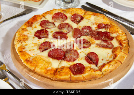 Eine Platte mit Pepperoni Pizza auf eine weiße Abdeckung Tabelle (Restaurant). Stockfoto