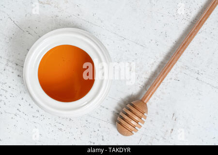 Von oben nach unten anzeigen, Honig Pendelarm und weißem Porzellan Topf auf Stein Schreibtisch Stockfoto