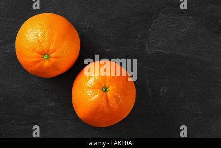 Tischplatte - zwei Orangen auf schwarzem Schiefer, Platz für Text rechts Stockfoto