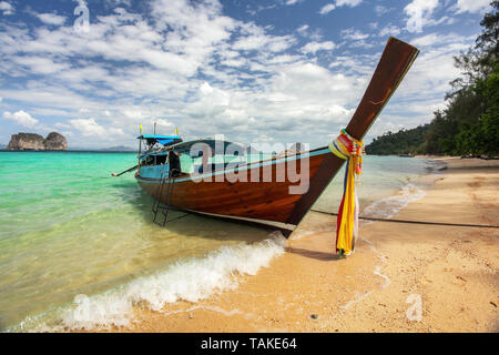 Thailand typische Long-tail-Boot auf dem azurblauen Meer, Himmel mit kleinen Wolken über, Golden Beach auf der rechten, KOH Kradan Insel Krabi Region Stockfoto