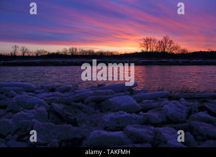 Der Grand River bei Sonnenaufgang mit Eisbrocken am Ufer. Schuß in Waterloo, Ontario, Kanada. Stockfoto