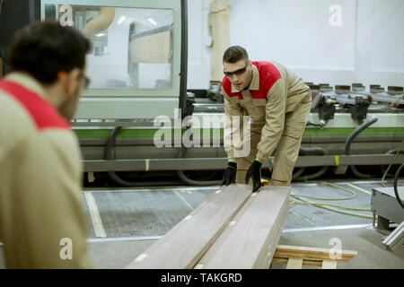 Zwei schöne und junge Männer in der Möbelfabrik arbeiten Stockfoto