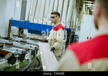 Zwei schöne und junge Männer in der Möbelfabrik arbeiten Stockfoto