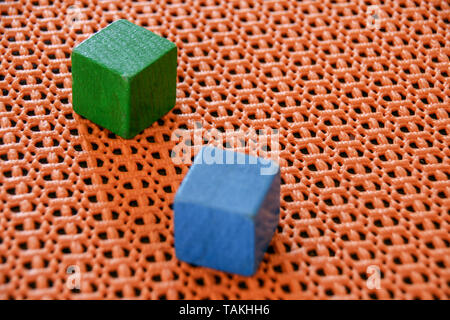 Zwei Holz- Spielzeug Würfel auf eine Orange plastik hintergrund. Stockfoto