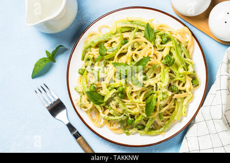 Pasta Spaghetti mit Zucchini, Erbsen und Sahnesauce. Vegetarisches Gemüse Pasta. Zucchini Nudeln. Ansicht von oben kopieren. Stockfoto