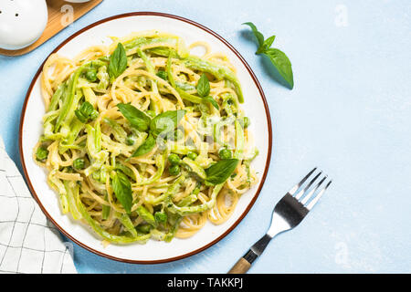 Pasta Spaghetti mit Zucchini, Erbsen und Sahnesauce. Vegetarisches Gemüse Pasta. Zucchini Nudeln. Ansicht von oben kopieren. Stockfoto