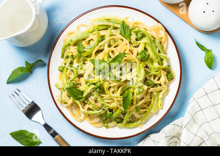 Pasta Spaghetti mit Zucchini, Erbsen und Sahnesauce. Vegetarisches Gemüse Pasta. Zucchini Nudeln. Ansicht von oben kopieren. Stockfoto