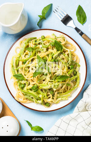 Pasta Spaghetti mit Zucchini, Erbsen und Sahnesauce. Vegetarisches Gemüse Pasta. Zucchini Nudeln. Ansicht von oben kopieren. Stockfoto