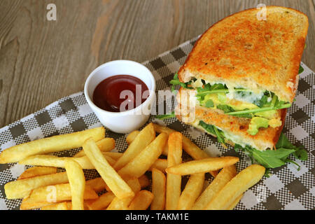 Huhn avocado Salat Sandwich und Pommes frites auf hölzernen Tisch serviert Stockfoto