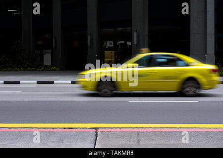 Taxi von Singapur Antriebe Vergangenheit in einer Motion Blur auf leeren Stadt Straße. Stockfoto