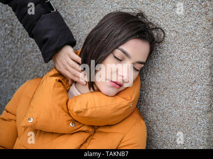 Weibliche Passanten Kontrolle Puls der Bewusstlose junge Frau im Freien Stockfoto