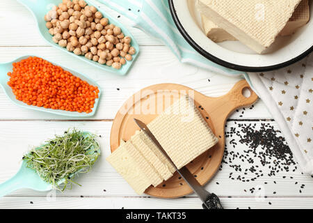 Schneidbrett mit leckeren tofu Käse, Linsen und Sprossen auf weißen Tisch Stockfoto