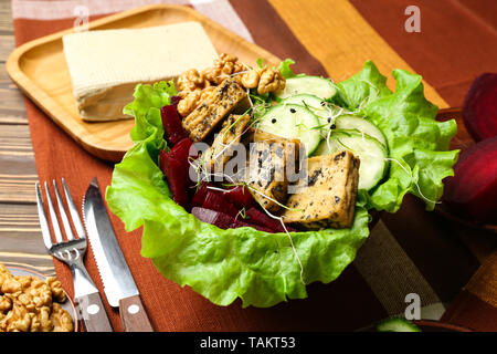 Gesunde Salate mit leckeren tofu Käse in der Schüssel auf dem Tisch Stockfoto