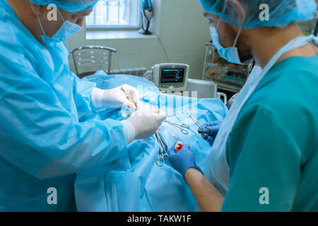 Gruppe von Chirurgen im Operationssaal mit Chirurgie. Medizinischen Hintergrund. Stockfoto