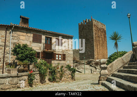 Altes, rustikales Haus und der viereckige Turm hinter einer Steintreppe in Gournes. Ein mittelalterliches Dorf mit einzigartiger Architektur in Osteuropa Portugal. Stockfoto