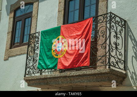 Portugiesische Flagge auf dem schmiedeeisernen Geländer aus Stein Balkon in Gournes. Ein mittelalterliches Dorf mit einzigartiger Architektur in Osteuropa Portugal. Stockfoto