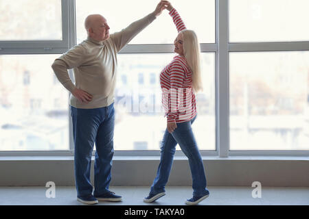 Ältere Paare tanzen in der Nähe der Fenster Cute Stockfoto